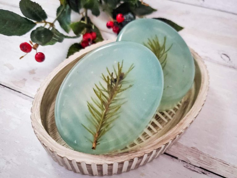 two bars of pine scented soap in a dish with holly decorations